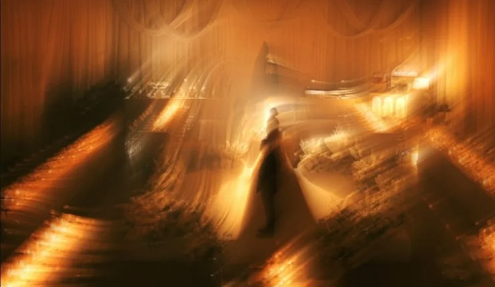 A figure moving through warm amber light and intentional blur.